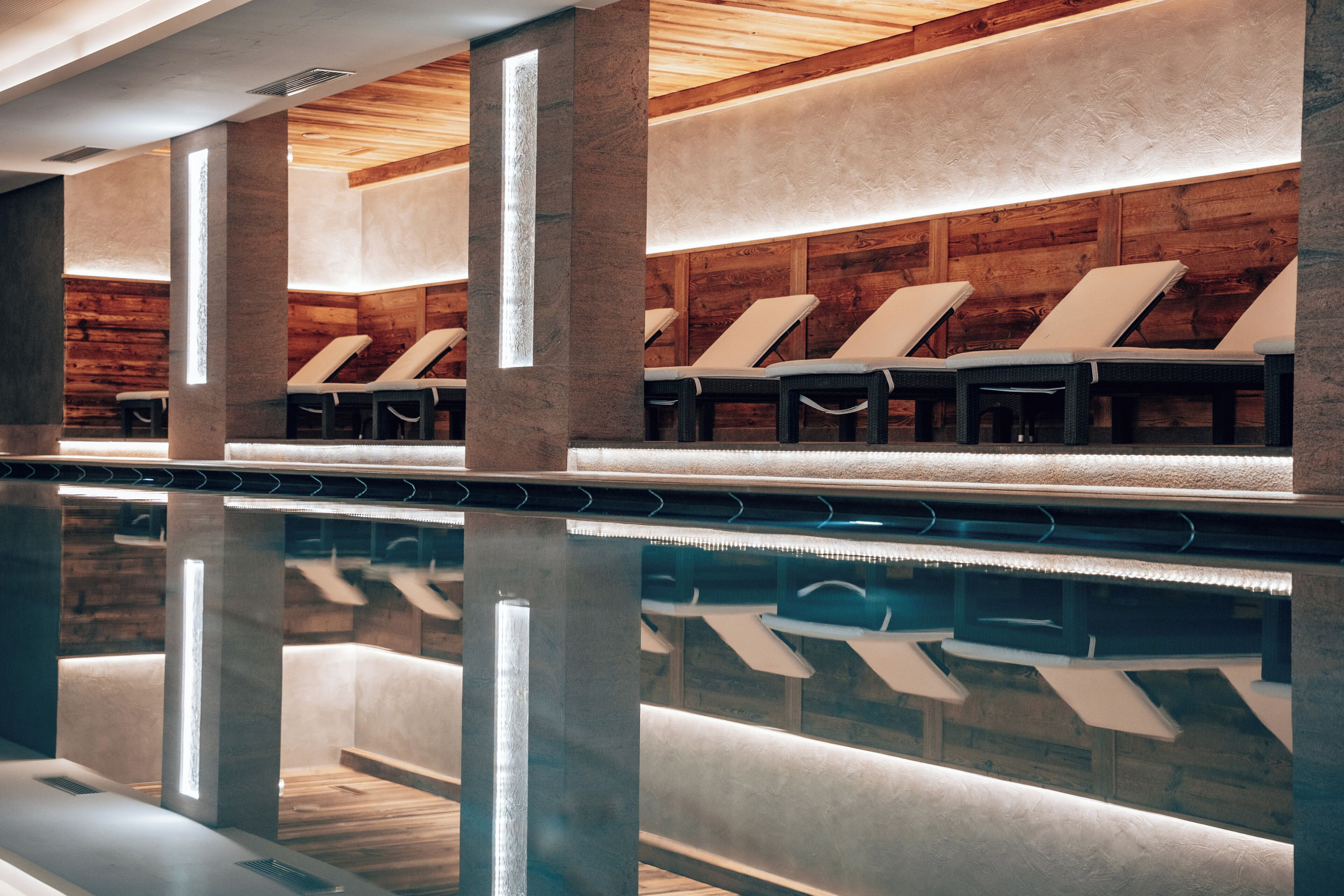 Una piscina techada, sillones reclinables de piscina