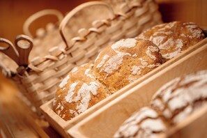 Ein Holzbrotkorb mit verschiedenen Brotscheiben.