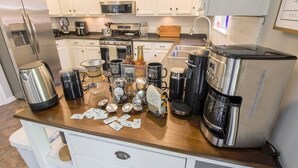 Une cuisine avec des armoires blanches, des appareils en acier inoxydable et un comptoir en bois.