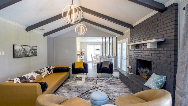 Un salon moderne avec un canapé, des fauteuils, des poufs et une cheminée.