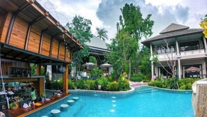 A resort with a swimming pool, bar area, and multiple buildings with balconies. - J4 Samui Hotel (Koh Samui)