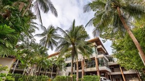 A multi-story hotel with a central courtyard surrounded by palm trees and greenery. - J4 Samui Hotel (Koh Samui)