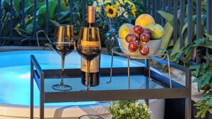 Ein Tisch mit zwei Weingläsern, einer Flasche und einer Obstschale.