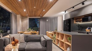 Ein modernes Wohnzimmer mit Sofa, Couchtisch und Fernseher.