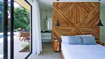 A modern hotel room with a large bed, a wooden headboard, a nightstand, and a view of the outdoors.