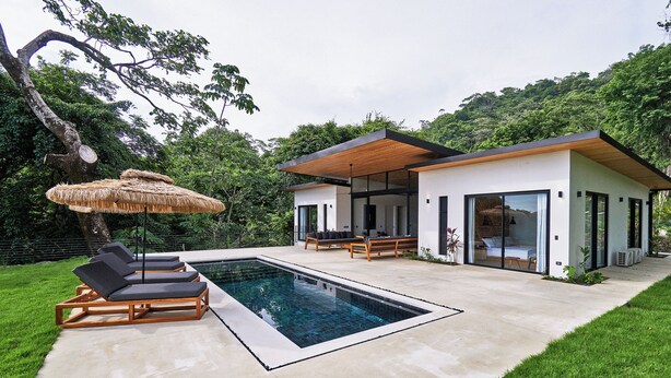 A modern house with a swimming pool, lounge chairs, and a covered patio area. - Villa Alba (Cóbano)
