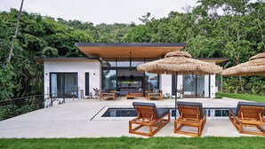 A modern house with a pool, wooden lounge chairs, and thatched umbrellas. - Villa Alba (Cóbano)