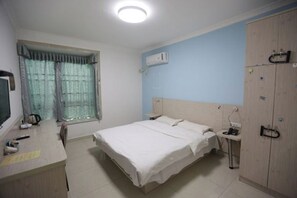 A bedroom with a bed, bedside table, wardrobe, and a window with curtains. - Meimei Apartment (Nanchang County)