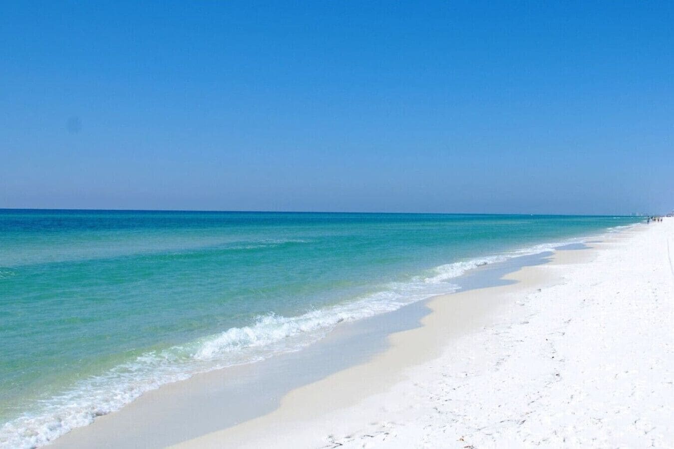 Uma praia com águas turquesa cristalinas e areia branca.