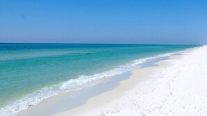 Una playa con aguas turquesas cristalinas y arena blanca.