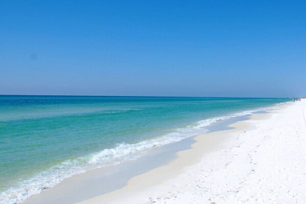 Ein Strand mit klarem türkisblauem Wasser und weißem Sand.