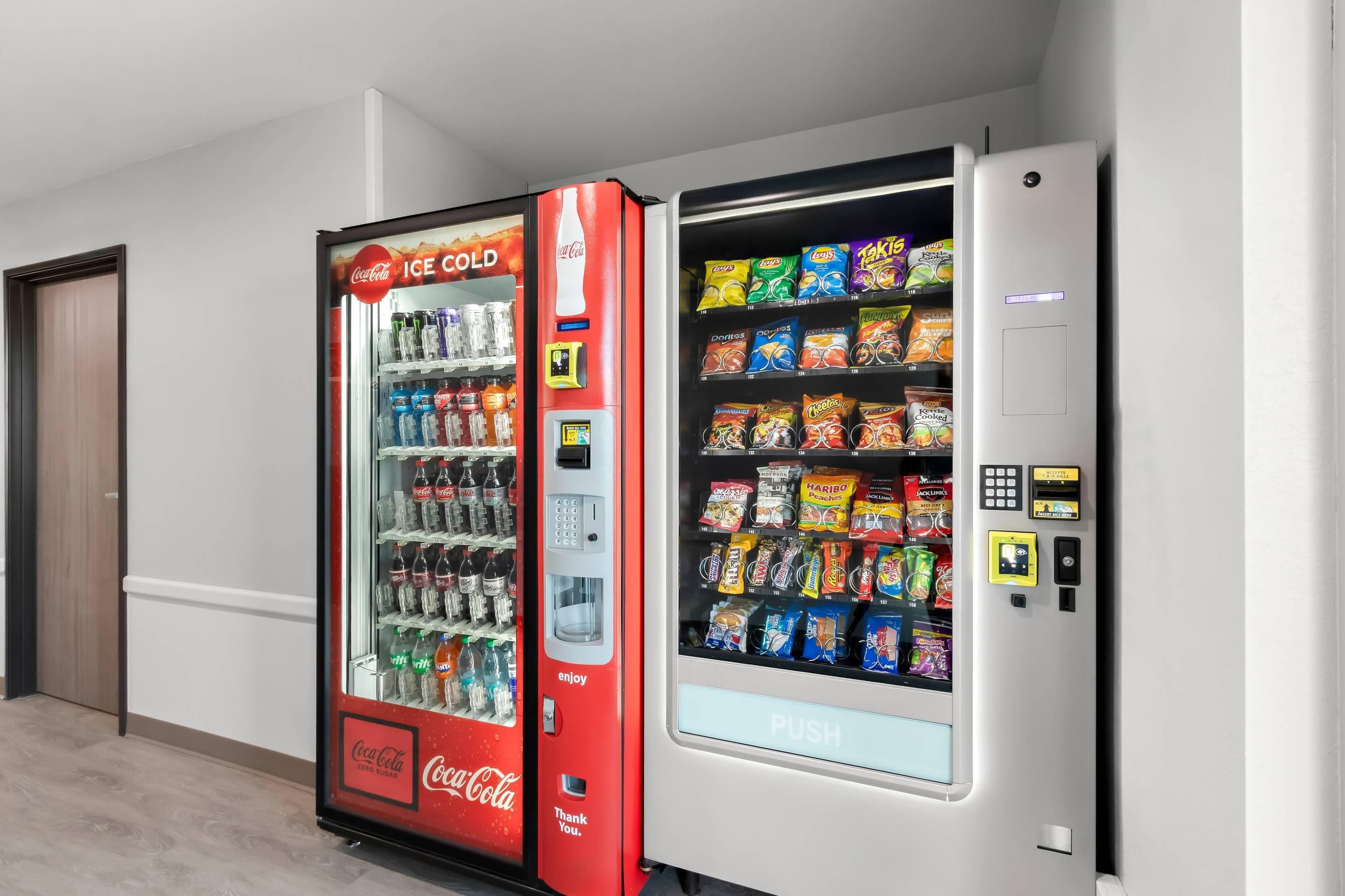 Un distributeur automatique doté d’un compartiment arborant la marque Coca-Cola et proposant une variété de collations.