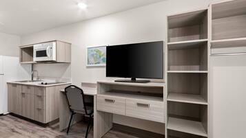 A compact kitchenette with a microwave, sink, and cabinet.