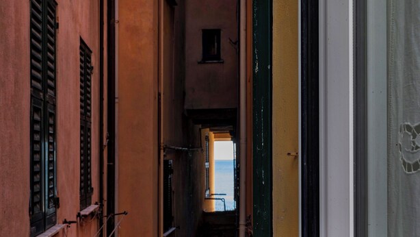 A narrow alleyway with buildings on either side, leading to a small window at the end. - La casa di Nanni a Camogli by Wonderful Italy (Camogli)