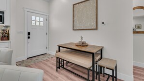Une cuisine moderne avec des meubles blancs, un four encastré et une fenêtre au-dessus de l’évier.