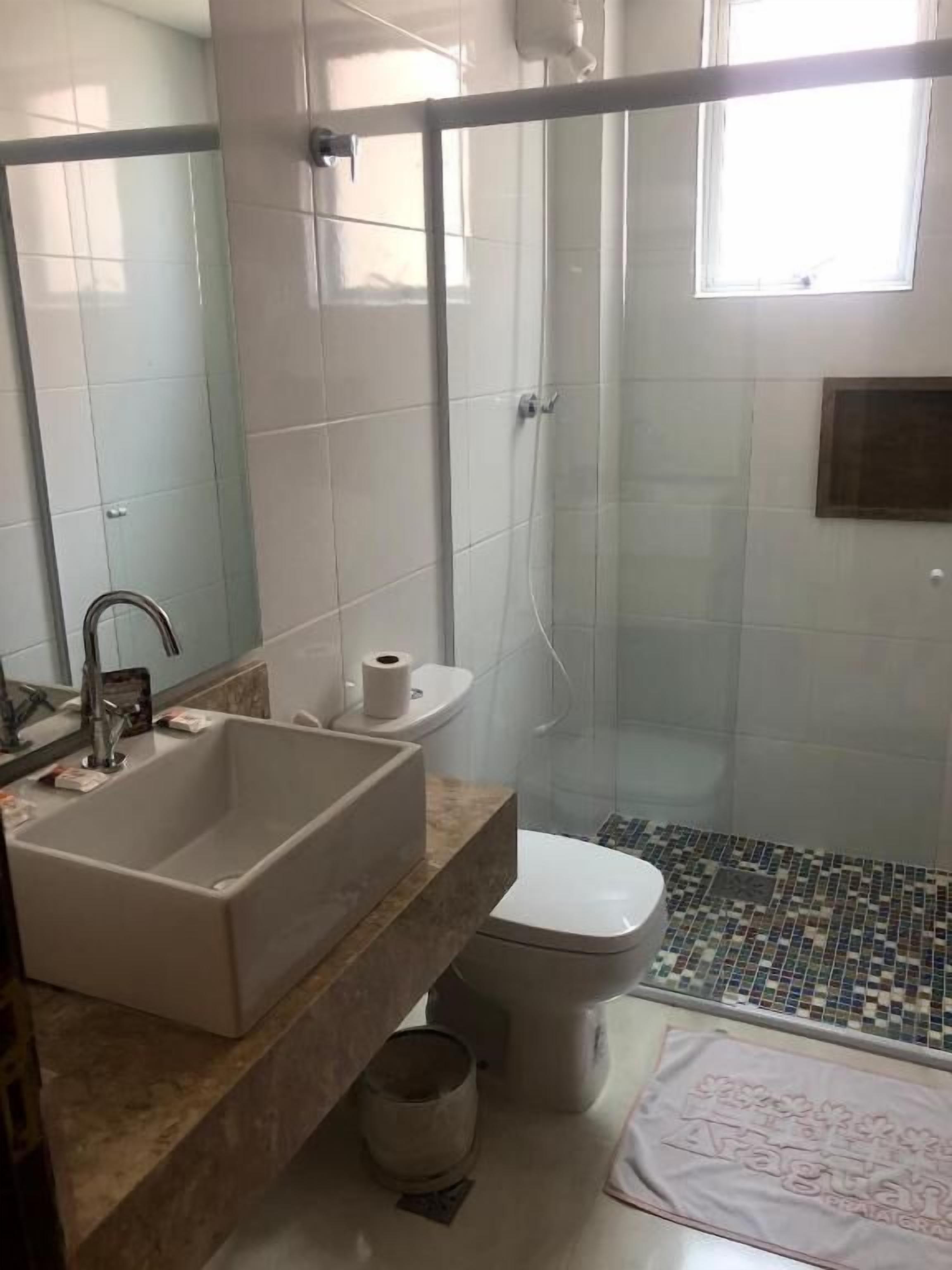 Ein Badezimmer mit Waschbecken, Toilette und Dusche.