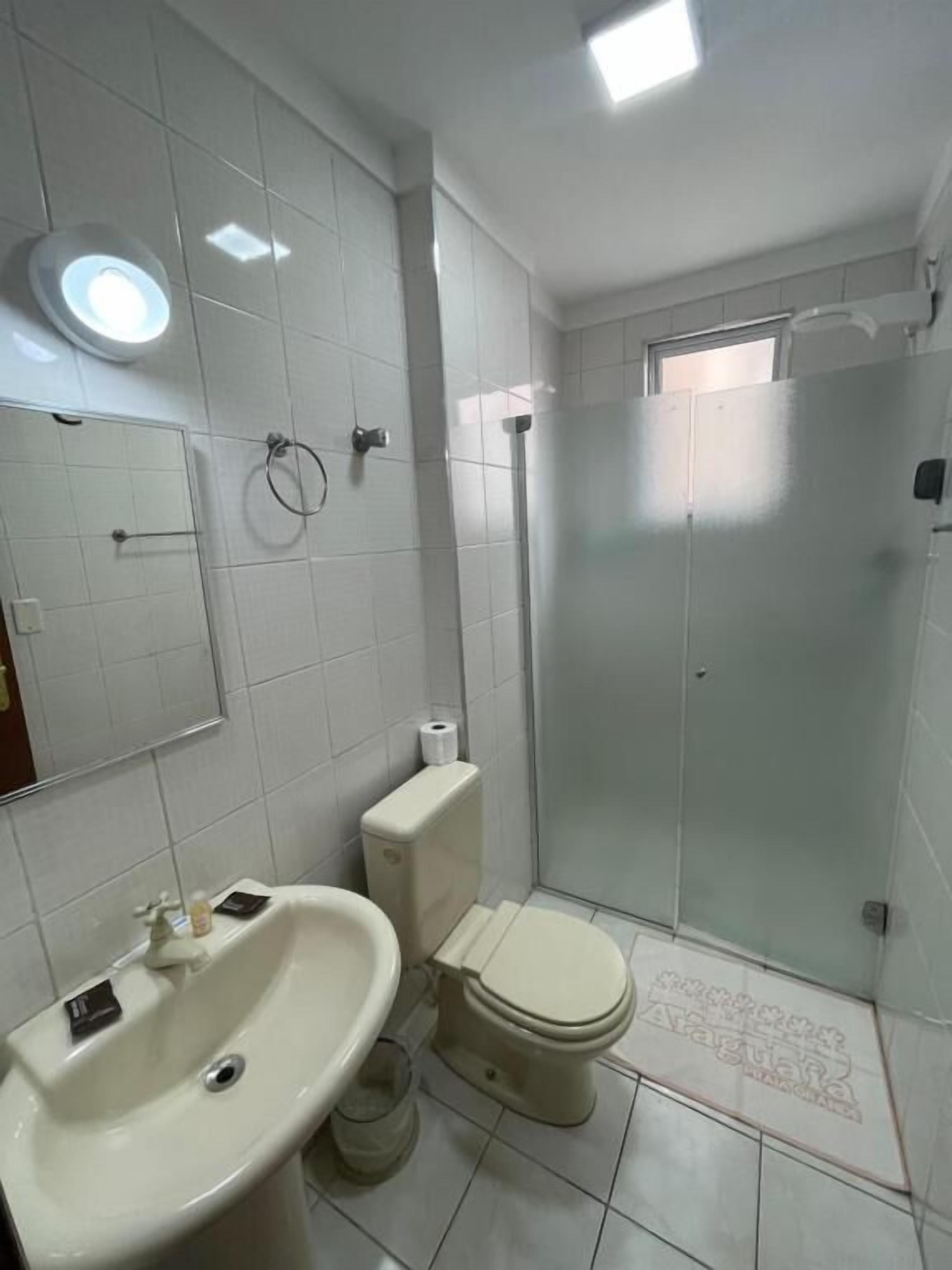 Ein Badezimmer mit Waschbecken, Toilette und einer Duschkabine.