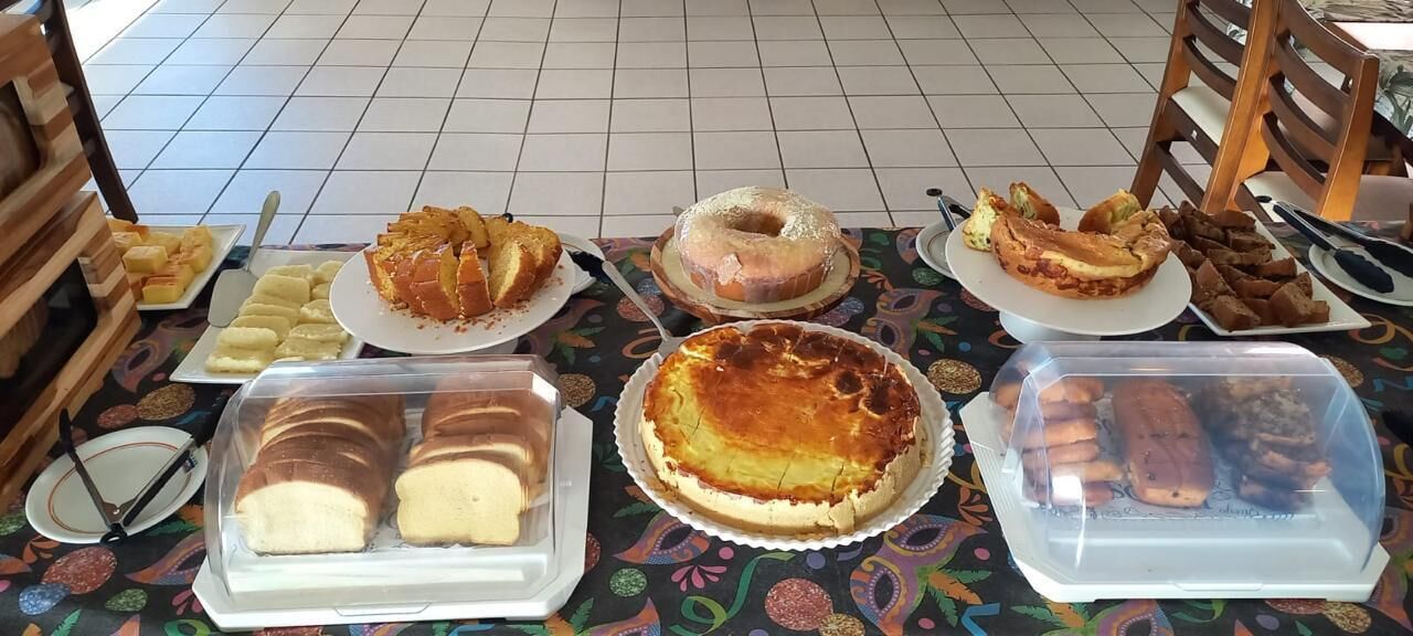 Una mesa con diversas opciones de panadería, incluyendo pasteles, tartas y productos de repostería.