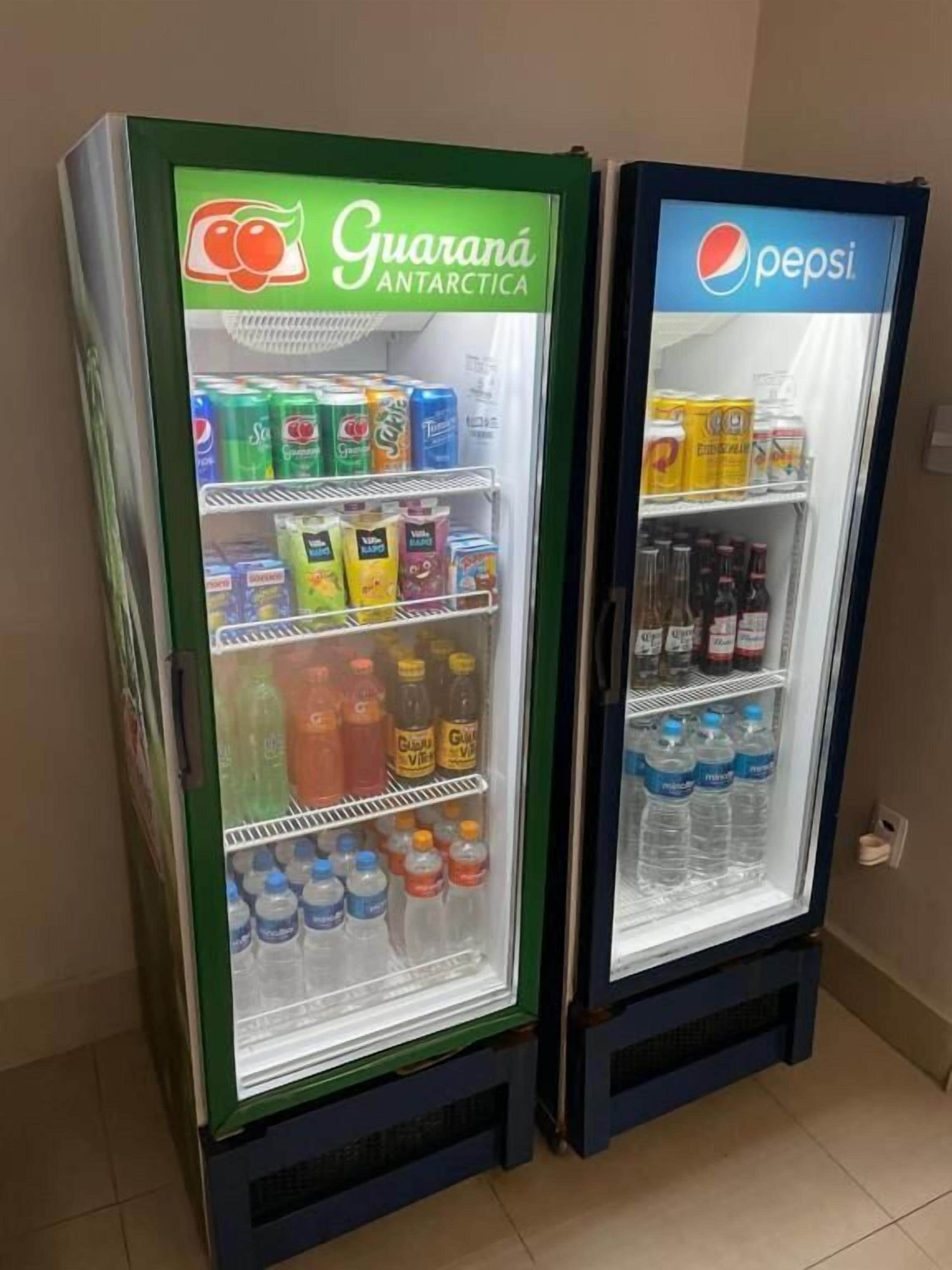 Two beverage vending machines, one labeled 'Guaraná Antarctica' and the other 'Pepsi', stocked with various drinks.