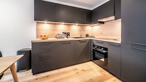 Eine moderne Küche mit dunklen Schränken, einer Holz Arbeitsplatte und integrierten Geräten.