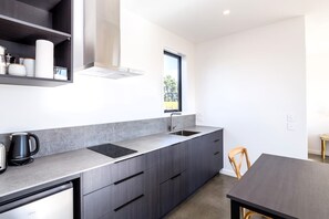 A modern kitchen with a built-in stove, a sink, and a window providing natural light.