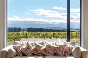 A room with a large window overlooking a vineyard. - 89 In The Vines, Martinborough (Martinborough)