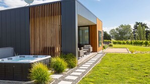 Un bâtiment moderne doté d’un jacuzzi, d’un espace extérieur aménagé et d’un jardin.