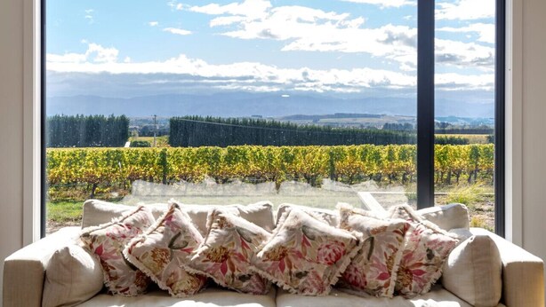 Une chambre dotée d’une grande fenêtre donnant sur un vignoble.