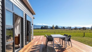 Una casa moderna con una terraza, una mesa y sillas.