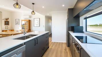 A modern kitchen with a central island, built-in appliances, and a large window providing a view.