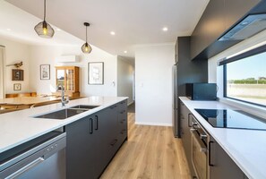 A modern kitchen with a central island, built-in appliances, and a large window providing a view.