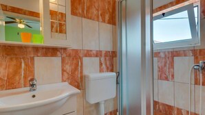 Ein Badezimmer mit Waschbecken, Toilette und Dusche.