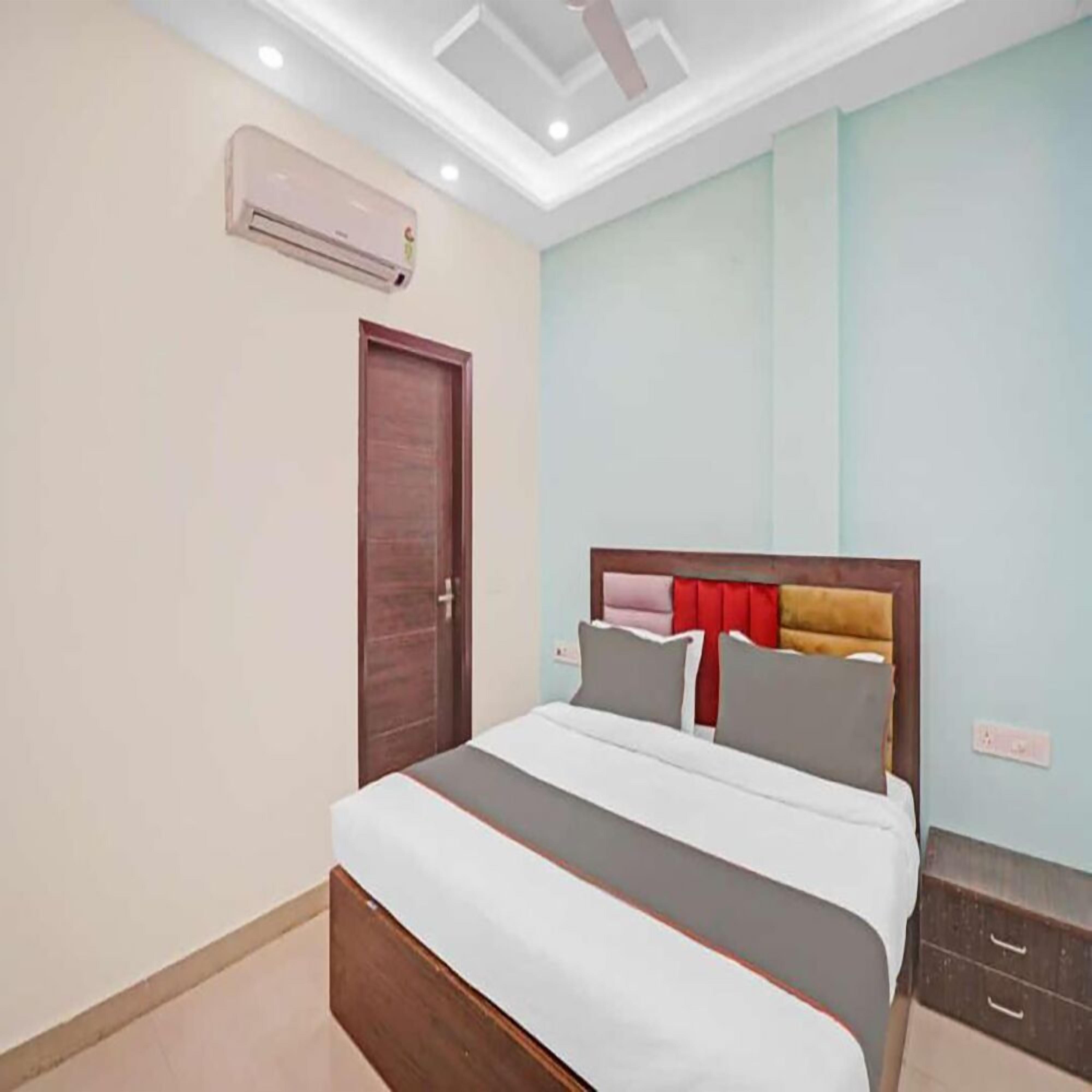 Une chambre à coucher comprenant un lit, une armoire et un appareil de climatisation fixé au mur.