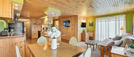 A wooden interior with a dining area, kitchen, and seating space.