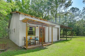 A small, single-story cabin with a porch, a table, and two chairs. - Lake Butler Cabin on 5 Acres w/ Fire Pit! (Lake Butler)