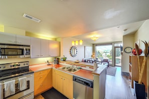 Una cocina moderna con electrodomésticos de acero inoxidable, armarios de madera y una isla grande con un lavamanos.