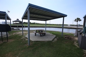 Relax by the water's edge at this serene outdoor space, featuring a covered picnic table and gazebo.