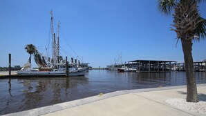 Un port de plaisance avec des bateaux amarrés, un palmier et une structure abritée.