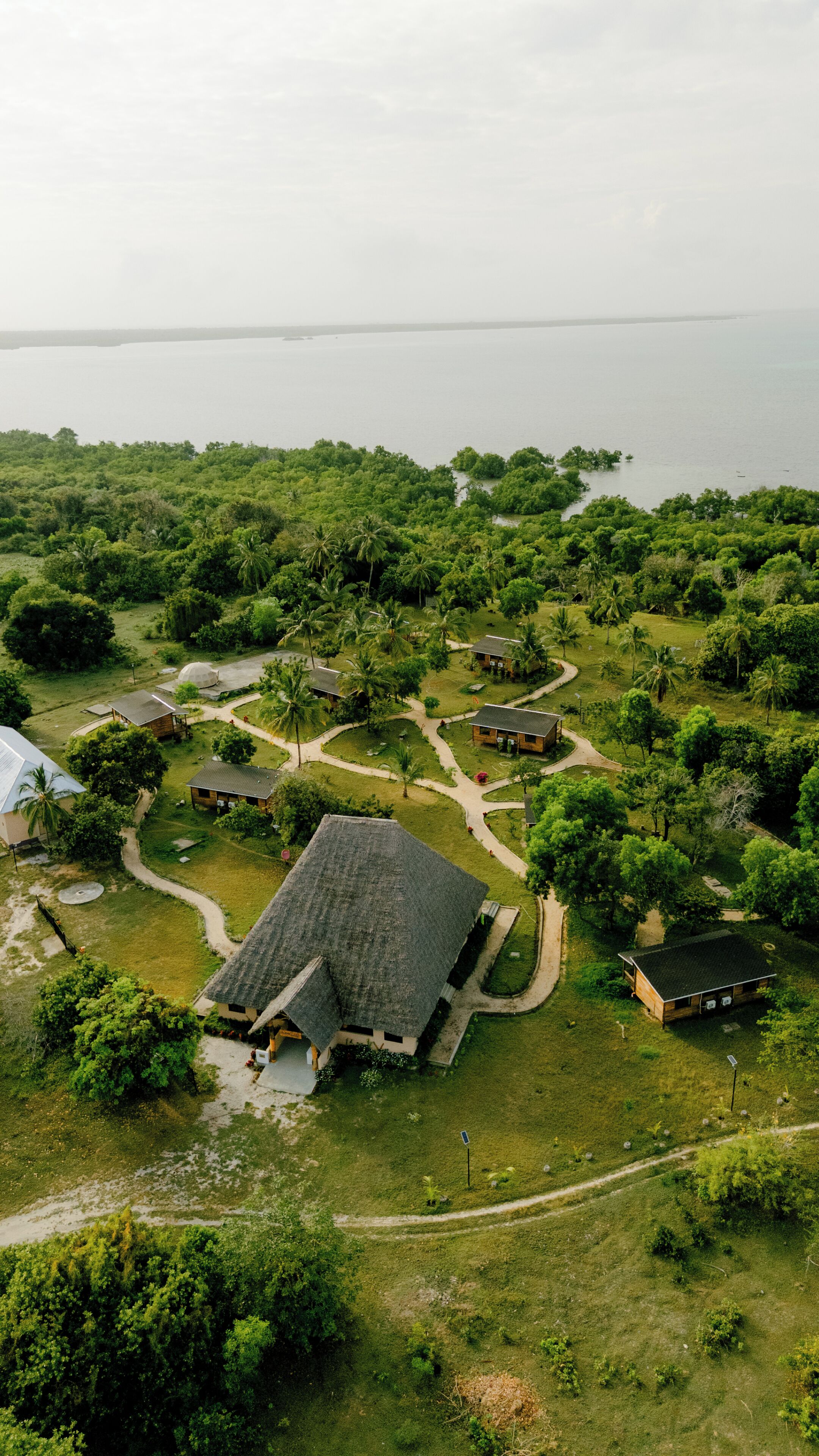 Vista aérea de um resort com vários edifícios, caminhos e vegetação exuberante.