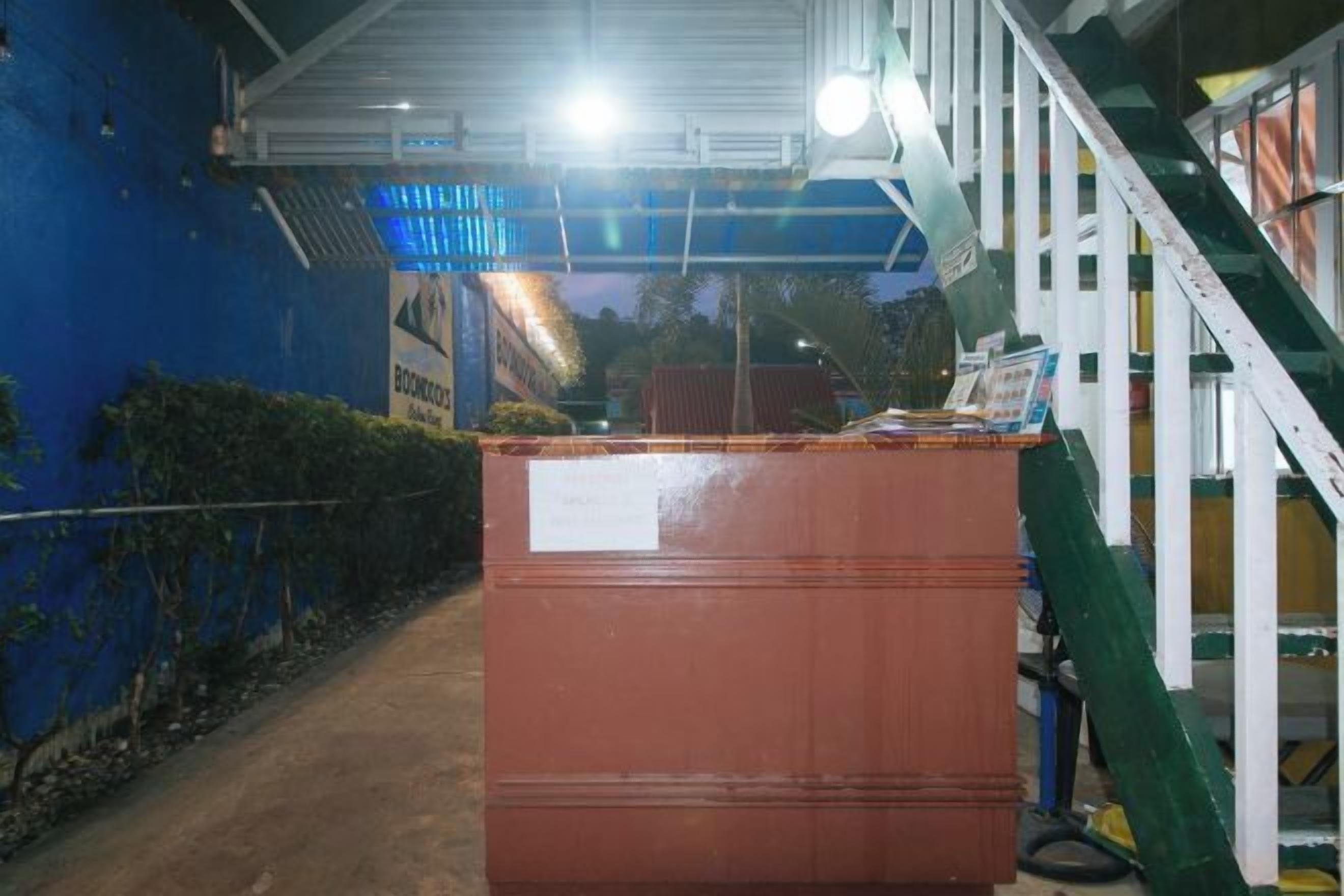 Um grande contêiner retangular de metal em um ambiente industrial, com uma escada e corrimãos ao fundo.