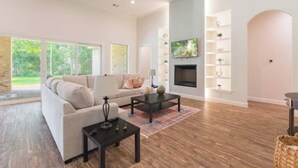 A spacious living room with a fireplace, a sofa, and a coffee table. - New 4bdr in Gated Comm + HUGE Summer Kitchen Area (Tomball)