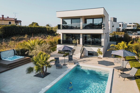 A modern two-story house with a swimming pool, outdoor seating, and a hot tub. - Luxurious 3-BR spa villa with heatable pool close to beaches (Poreč)