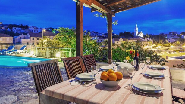 A table set for dining with a pool in the background. - Charming 3-BR Villa for 6 with private pool, close to the sea (Sumartin)