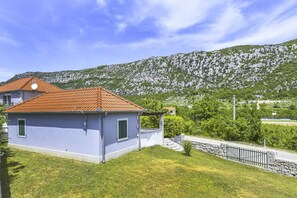 Situated in a lush landscape, this single-story building features a simple design with a flat facade and a small porch area.
