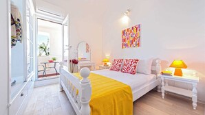 Een lichte slaapkamer met een bed, nachtkastjes en een raam.