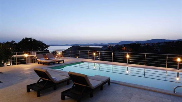 A rooftop pool area with lounge chairs and a view of the sea. - Modern Villa Mermaid in Podstrana with pool (Podstrana)