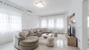 Una sala de estar moderna con un sofá seccional, un televisor de pantalla plana y una mesa de centro.