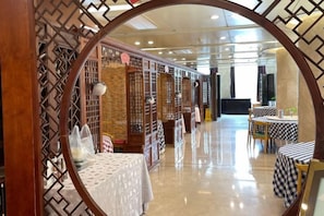 A modern interior with a reflective floor, wooden partitions, and tables with checkered tablecloths. - Guomao Hotel (Zhangjiagang)