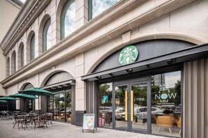 A Starbucks store with outdoor seating and a large window display.