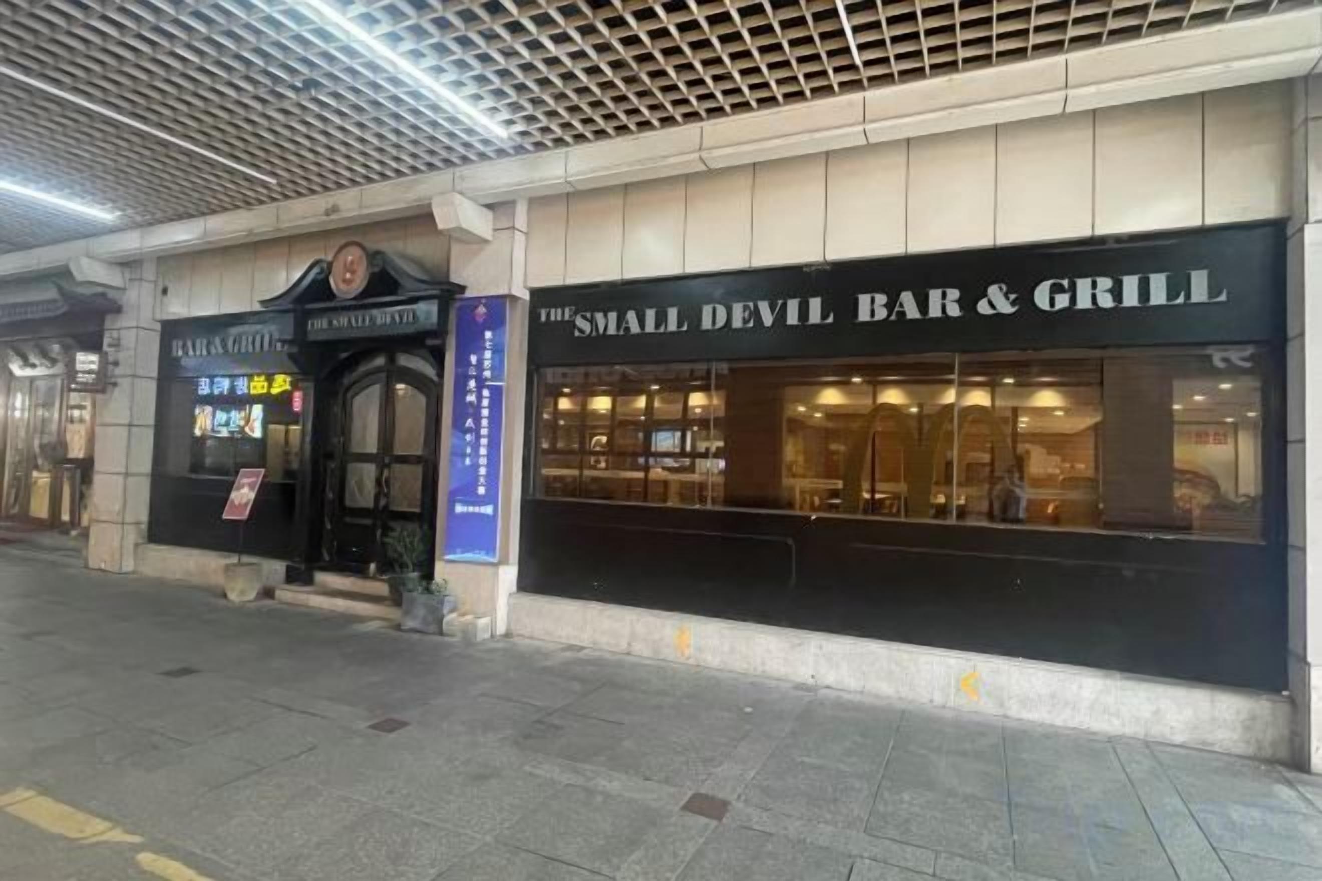 A building with a storefront labeled 'The Small Devil Bar & Grill.'